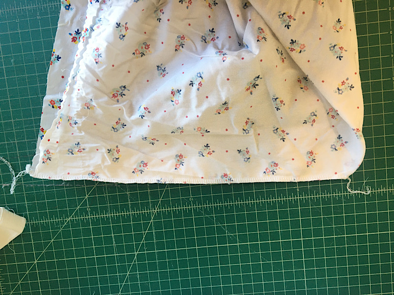 Sewn edge of fitted sheet corner smaller