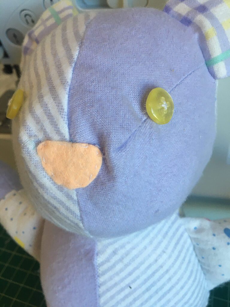 sewing buttons on a bear