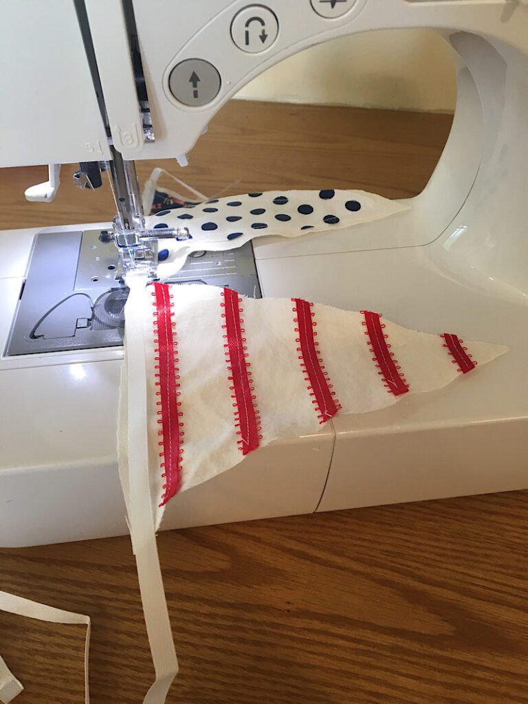 sewing the pennants to the garland