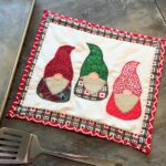 christmas gnome applique mug rug on table with sheet pan