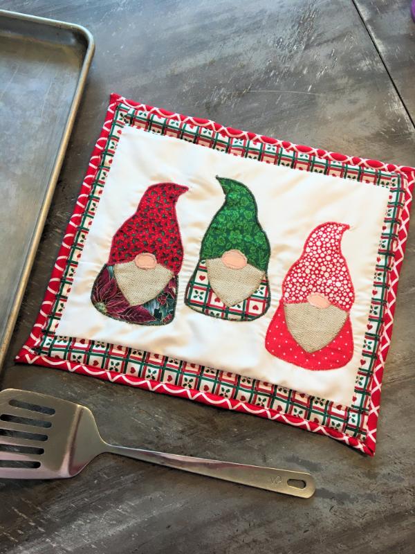 christmas gnome applique mug rug on table with sheet pan