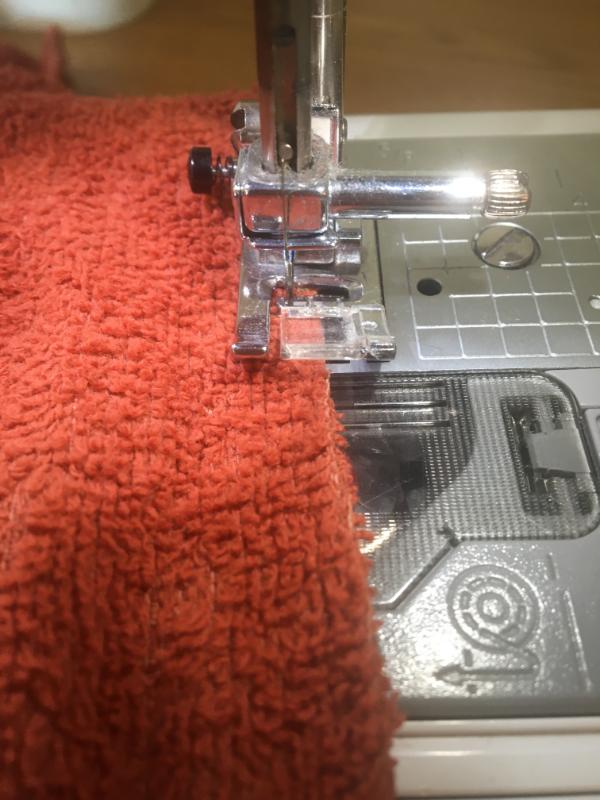 sewing a zig zag stitch around a rag towel